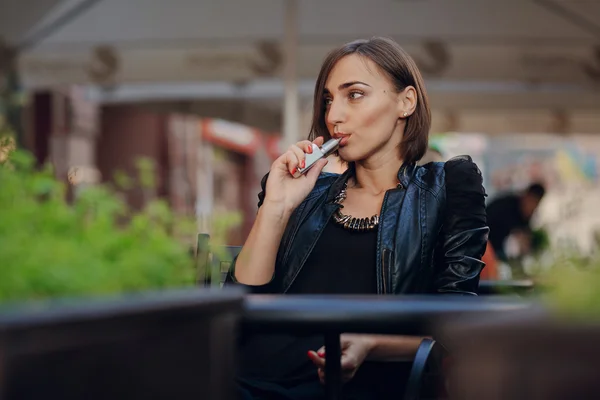 Krásné okouzlující brunetka dým elektronické cigarety — Stock fotografie