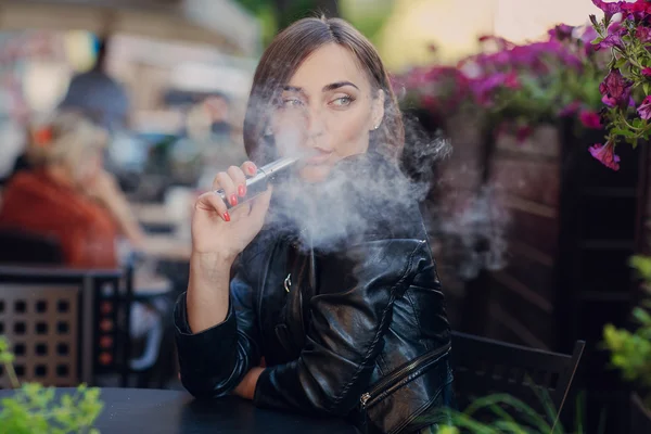 Krásné okouzlující brunetka dým elektronické cigarety — Stock fotografie