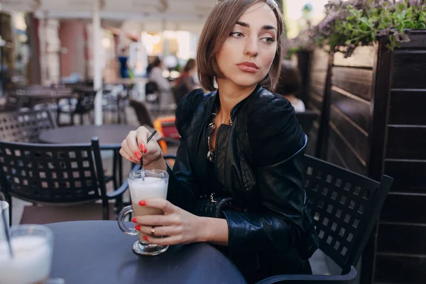 Hermosa chica bebiendo un capuchino en un café — Foto de Stock