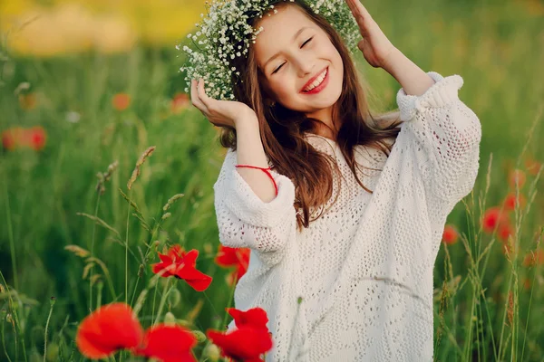 Hermosa niña posando en una falda corona de amapolas — Foto de Stock