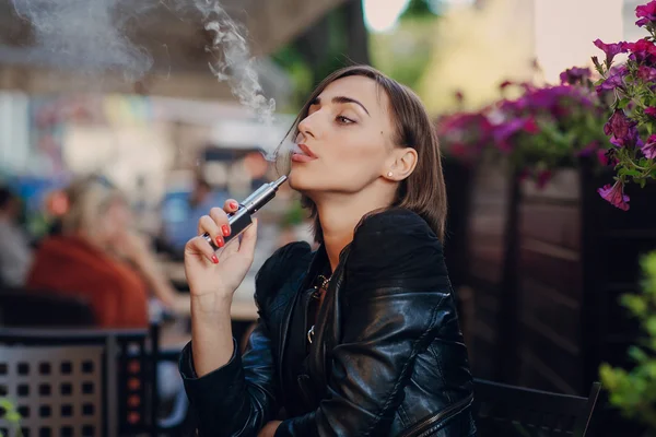 Krásné okouzlující brunetka dým elektronické cigarety — Stock fotografie