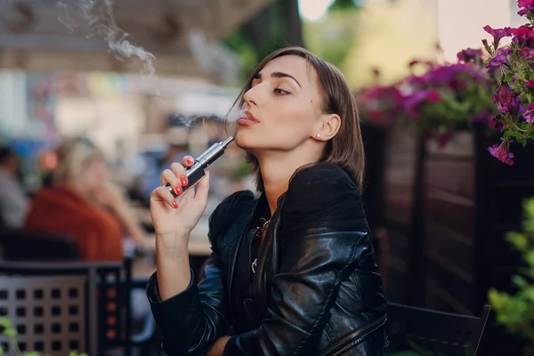 Krásné okouzlující brunetka dým elektronické cigarety — Stock fotografie