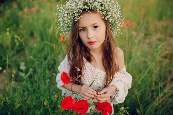 Красива маленька дівчинка позує в спідниці вінок з маками — стокове фото
