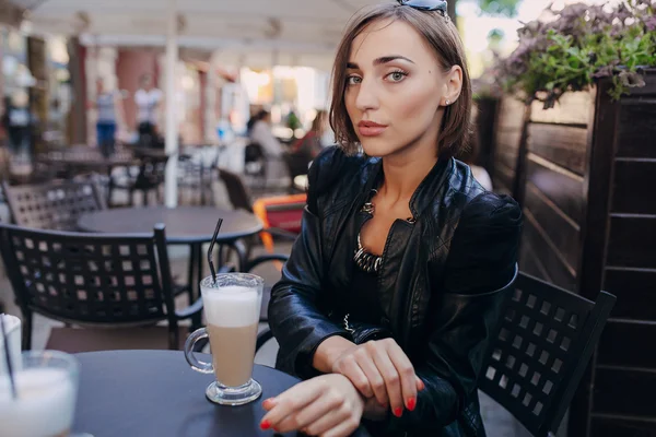 Menina bonita bebendo cappuccino em um café — Fotografia de Stock