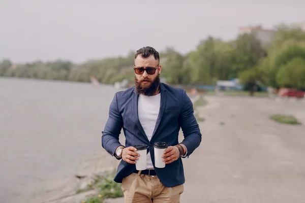 Бородатий чоловік носить каву — стокове фото