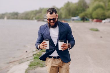 Kahve taşıyan sakallı adam.