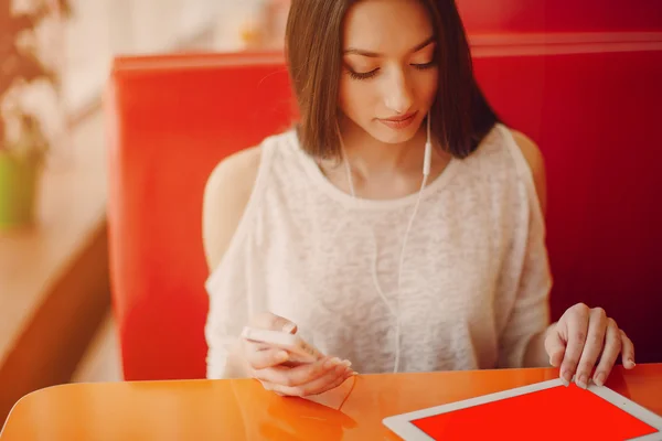 Schöne junge Mädchen genießt Telefon und Tablet — Stockfoto