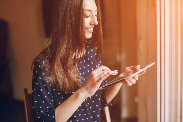 Hermosa chica joven disfruta del teléfono y la tableta — Foto de Stock