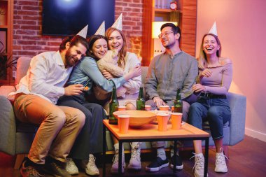 Genç arkadaşlar akşam partisinde arabada oturuyorlar. Herkes parti konisi takıyor. Ortadaki kız arkadaşlarından bir hediye aldı. Ayı oyuncağı..