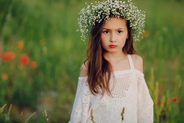 Красива маленька дівчинка позує в спідниці вінок з маків — стокове фото
