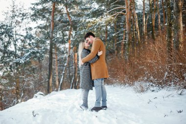 karlı bir günde parkta yürüyen mutlu genç çift