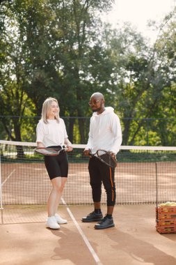 Sümer mevsimi. Raketli genç siyahi adam ve kız çocuk parkında sohbet ediyorlar. Tenis, hobiler..