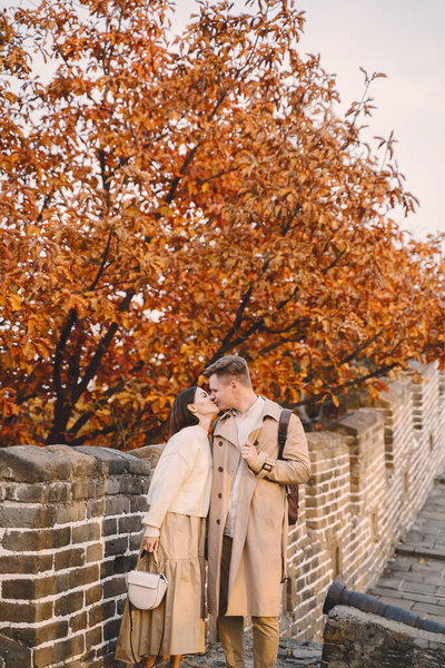 young couple kissing at the Great Wall of China. Newly married couple on their honeymoon to the Great Wall of China near Beijing China.