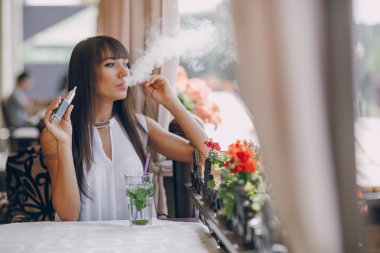 girn in cafe with E-Cigarette clipart