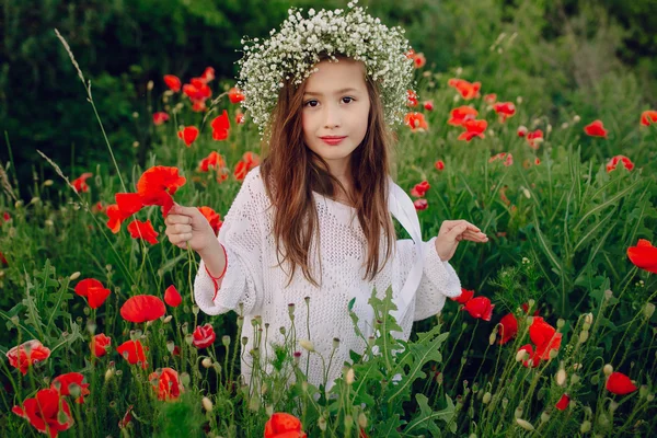 Красива маленька дівчинка позує в спідниці вінок з маків — стокове фото