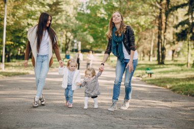 Genç bir aile parkta yürüyor.