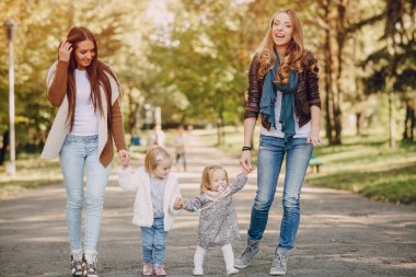 Genç bir aile parkta yürüyor.