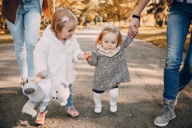 Genç bir aile parkta yürüyor.