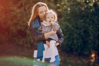 Genç bir aile parkta yürüyor.