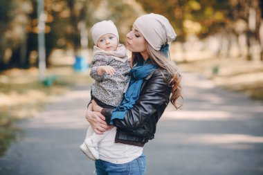Genç bir aile parkta yürüyor.