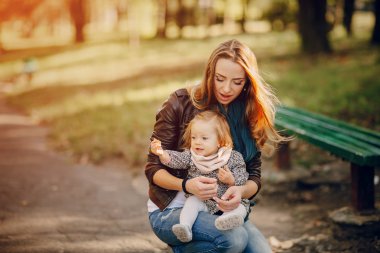 Genç bir aile parkta yürüyor.