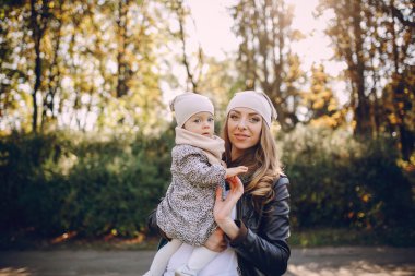 Genç bir aile parkta yürüyor.