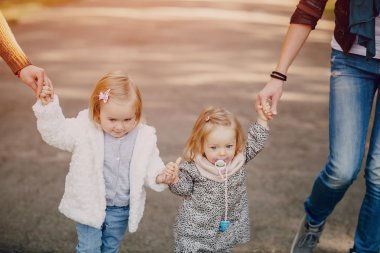 Genç bir aile parkta yürüyor.