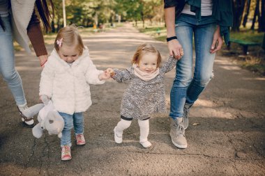 Genç bir aile parkta yürüyor.