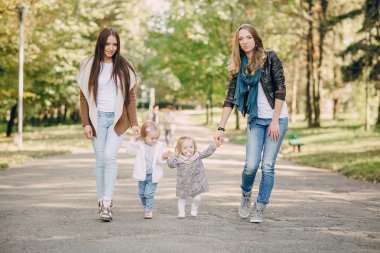 Genç bir aile parkta yürüyor.