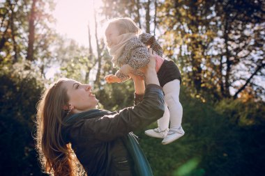 Genç bir aile parkta yürüyor.