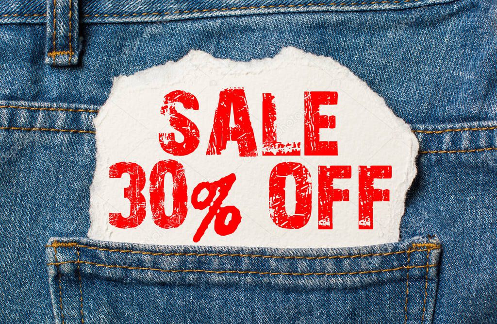 Sale 30 off on white paper in the pocket of blue denim jeans
