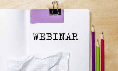 Ofisteki masanın üzerinde kalemler olan bir kağıda yazılmış WEBINAR metni