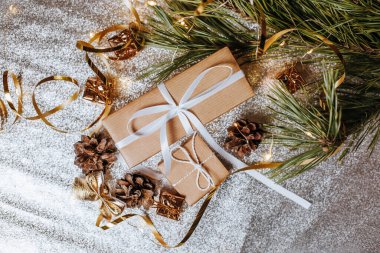 Yılbaşı hediyeleri kozalaklı ışıklarda ve köknar dalları gümüşi arka planda şenlikli yeni yıl atmosferinde