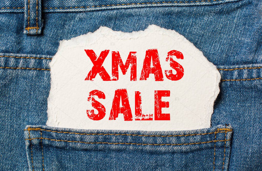 xmas sale on white paper in the pocket of blue denim jeans