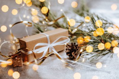 Yılbaşı hediyeleri kozalaklı ışıklarda ve köknar dalları gümüşi arka planda şenlikli yeni yıl atmosferinde