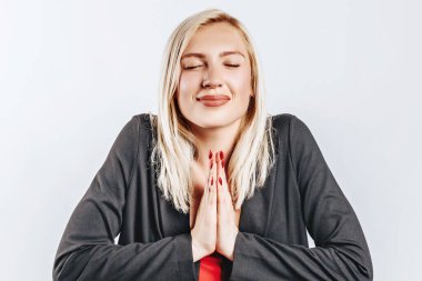 Güzel, mutlu, genç bir kız gri arka planda gülümsüyor.