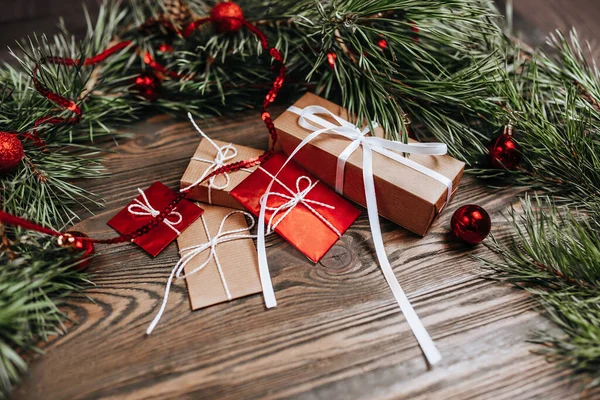Yeni yıl hediyeleri ahşap arka planda Noel ağacı ve oyuncaklarla