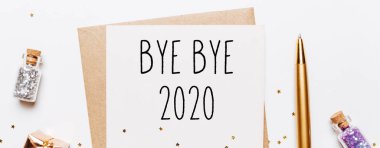 Güle güle 2020. Zarf, hediyeler ve beyaz arka planda altın parıltılı yıldızlar. Mutlu Noeller ve yeni yıl konsepti