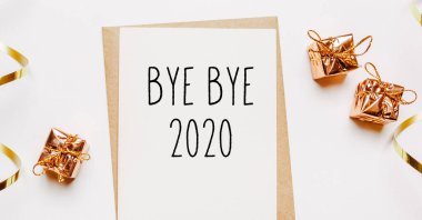 Güle güle 2020. Zarf, hediyeler ve beyaz arka planda altın kurdeleyle. Mutlu Noeller ve yeni yıl konsepti