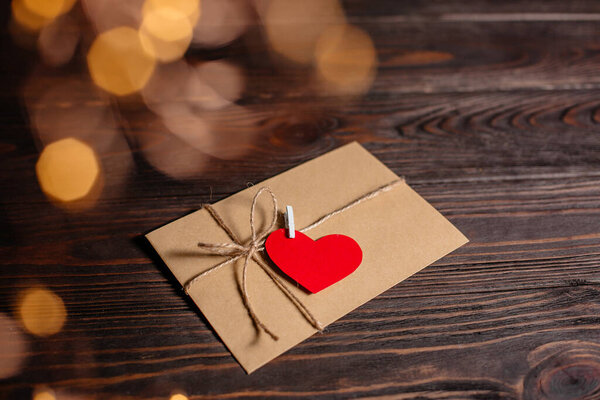 Любовное письмо с сердцем на фоне огней, любви и валентинки на деревянном столе