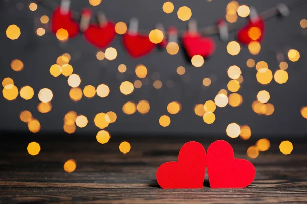 木製のテーブルの上のライトの背景 愛とバレンタインの概念に赤いハートのペア — ストック写真