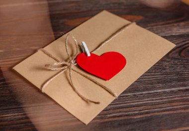 Bir aşk mektubu, arka planda ışıklar, aşk ve sevgililer günü konsepti olan ahşap bir masada.