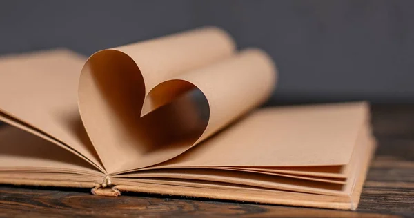 木製のテーブルの上に本のシート 愛とバレンタインの概念から作られた心 — ストック写真