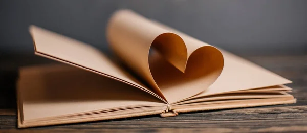 Heart made from book sheets, love and valentine concept on a wooden table