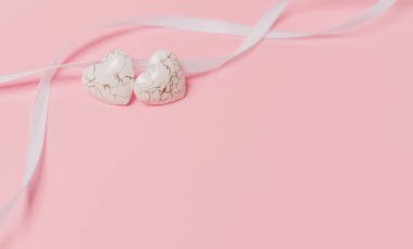 Pembe arka planda geniş kurdeleli bir kalp şekli.