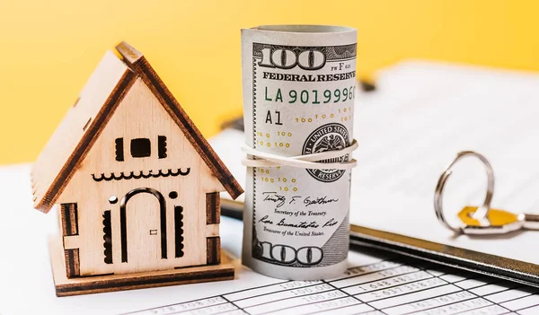 House miniature model and money on documents. Investment, real estate, home, housing