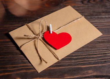 Bir aşk mektubu, arka planda ışıklar, aşk ve sevgililer günü konsepti olan ahşap bir masada.