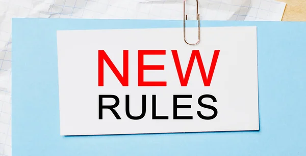 Text new rules on a white card on a blue background. Business concept