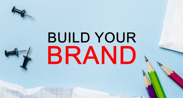 Text Build Your Brand Білому Блокноті Олівцями Синьому Фоні Концепція — стокове фото