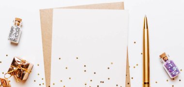 Zarflı boş bir not, hediyeler, beyaz arka planda altın ve kalem yıldızları.